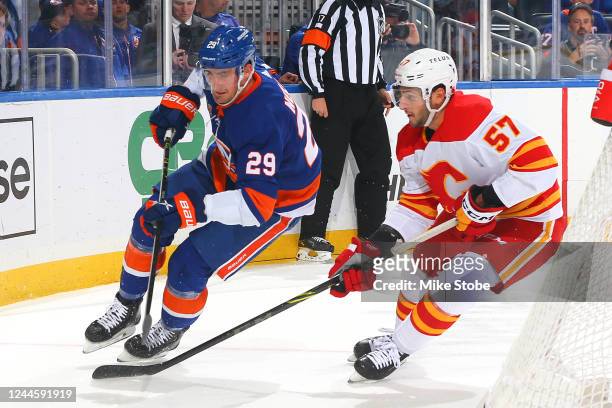 Brock Nelson of the New York Islanders is defended by Nick DeSimone of the Calgary Flames during the first period at UBS Arena on November 07, 2022...