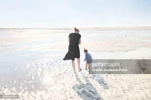 mother with daughter on spacious beach - mother and daughter in the wind stock-fotos und bilder
