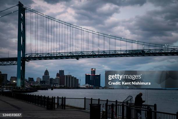Man fishes with the Detroit city skyline and the Ambassador bridge as a backdrop, as seen from Riverside Park on Sunday, Oct. 16, 2022 in Detroit, MI.