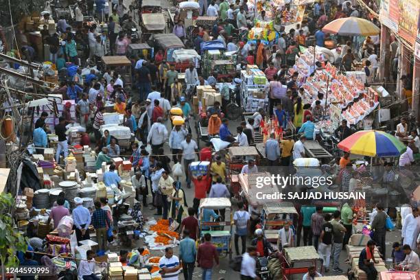 In this photograph taken on October 22 people crowd at a market in the old quarters of New Delhi. - India is projected to see an explosion in its...
