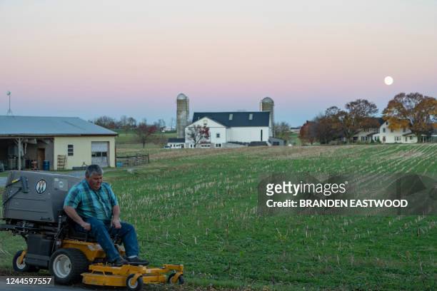 Man mows a very large field of grass in Lancaster County, Pennsylvania near the town of Bird-in-Hand on November 7, 2022 on the eve of the US midterm...