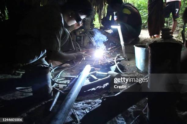 This screengrab from AFPTV video footage taken on October 4, 2022 shows members of the Pale People Defense Force welding as they producing homemade...