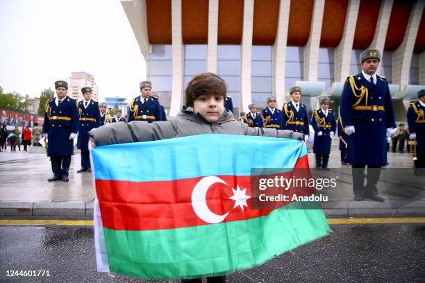 Child holds an Azerbaijani flag as Azerbaijani ceremonial soldiers parade to celebrate Azerbaijani army's victory in Nagorno-Karabakh in Baku,...