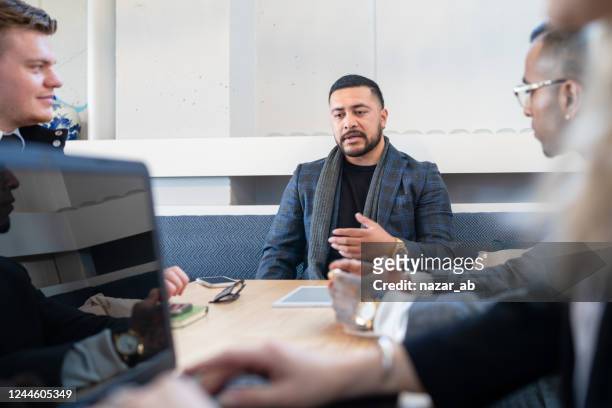 pacific island man taking lead in meeting. - new zealand maori people talking stock pictures, royalty-free photos & images