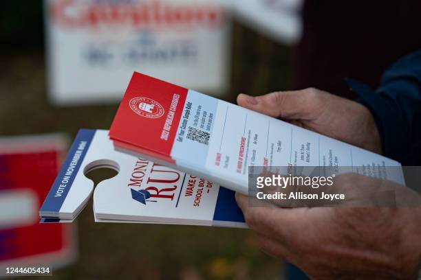 Advocates hand out flyers as people wait in line to vote at a polling place on November 8, 2022 in Fuquay Varina, North Carolina, United States....