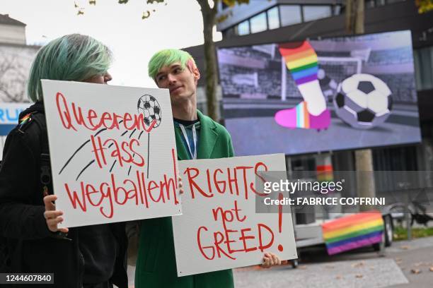 Activists hold boards reading in German "shooting at queer hate" during a symbolic action by LGBT+ associations in front of the FIFA museum in Zurich...