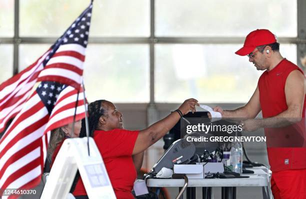 Voter is given a receipt by an official after turning in his ballot for the midterm elections at a polling station in Kissimmee, Florida on November...