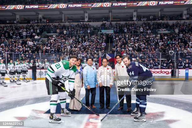 Jason Robertson of the Dallas Stars and Josh Morrissey of the Winnipeg Jets take part in the ceremonial face-off on Filipino Heritage Night prior to...