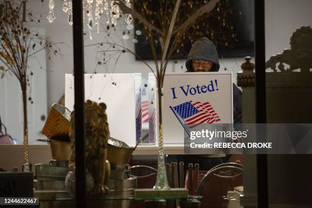 Voter casts his ballot inside a polling place at Elevationz, an event space and resale shop, before polls close for the evening, during the US...