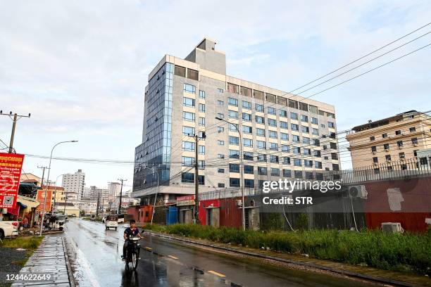 This photo taken on September 26, 2022 shows a motorist passing a building previously shut down by the police, in Sihanoukville in Preah Sihanouk...