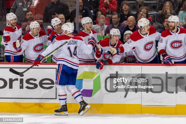 Nick Suzuki of the Montreal Canadiens pounds gloves with teammates on the bench after scoring a goal during the shoot-out of an NHL game against the...