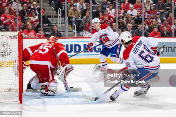 Kirby Dach of the Montreal Canadiens attempts a pass to teammate Mike Hoffman as Ville Husso of the Detroit Red Wings stops the puck during the O.T....