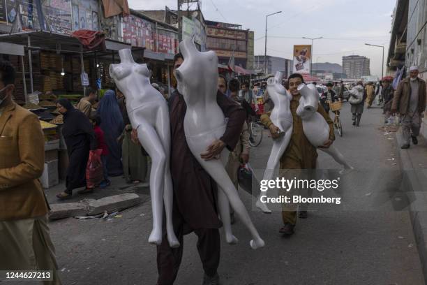 People carry mannequins through a market in Kabul, Afghanistan, on Sunday, Oct. 30, 2022. Afghanistan's economy has been in free fall since Taliban...