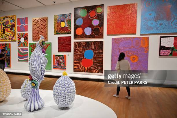 Member of the media looks at art works on a press preview tour of Japanese artist Yayoi Kusama titled 1945 to Now, at the M+ art museum in Hong Kong...