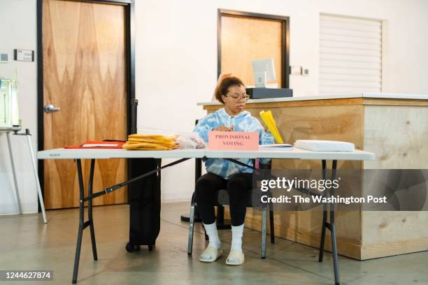 Carly Rogers works on paperwork prior to the polls opening at the precinct at Worship With Wonders Church in Marietta, Ga., on Tuesday, Nov. 8, 2022.