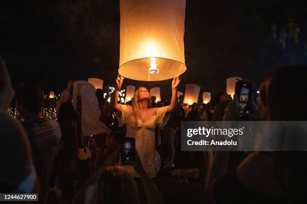 Woman holds a lantern during Yi Peng Festival & Loy Kratong in Doi Saket, Chiang Mai, Thailand on November 08, 2022. In the north of Thailand, Loy...