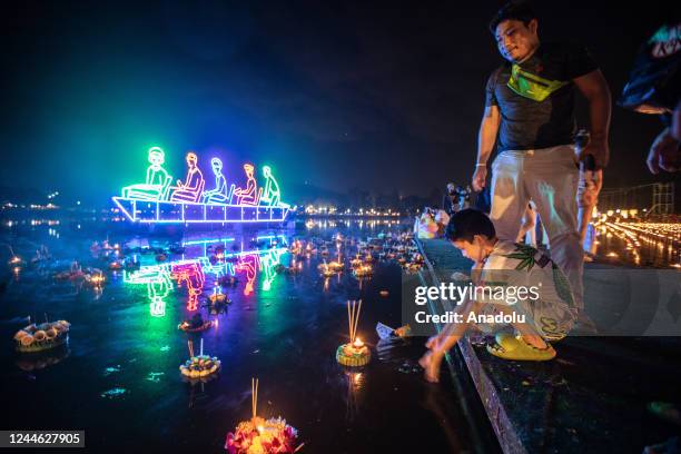 Young boy releases a Kratong during Yi Peng Festival & Loy Kratong in Doi Saket, Chiang Mai, Thailand on November 08, 2022. In the north of Thailand,...