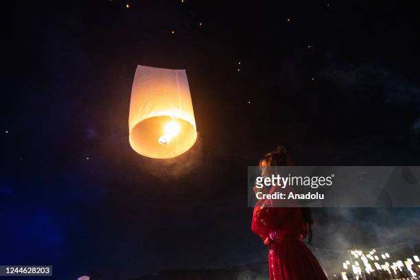 Woman wearing traditional Chinese clothes prays after releasing a lantern during Yi Peng Festival & Loy Kratong in Doi Saket, Chiang Mai, Thailand on...
