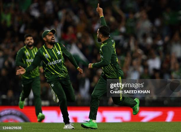 Pakistan's Mohammad Nawaz celebrates with Pakistan's Captain Babar Azam after his dismissal of New Zealand's Glenn Phillips during the ICC men's...