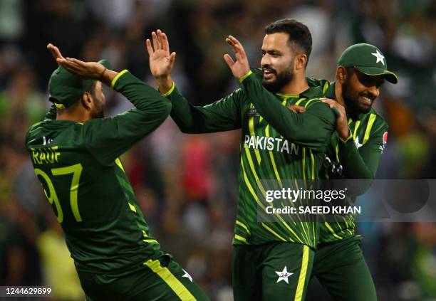 Pakistan's Mohammad Nawaz celebrates with Pakistan's Captain Babar Azam and Pakistan's Haris Rauf after his dismissal of New Zealand's Glenn Phillips...