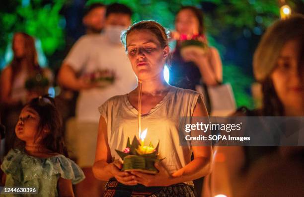 Foreign tourist in seen hold a "Krathong" during the Loy Krathong Festival at Ping river in Chiang Mai. The festival dates back more than 700 years...