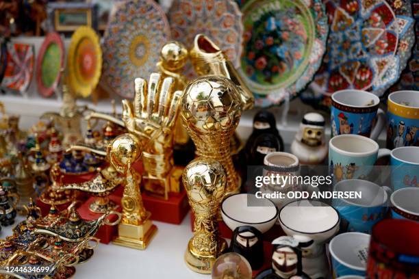 Football merchandise are displayed on a shelf outside a store in a market area in Doha on November 9 ahead of the Qatar 2022 FIFA World Cup football...