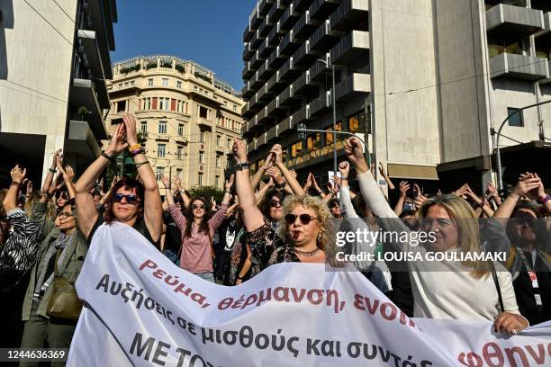 Teachers hold a banner during a 24-hours general strike called by unions and private sectors against rising prices and soaring inflation, in Athens...