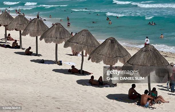 People enjoy a day at Playa Delfines beach at the Hotel Zone of Cancun, Quintana Roo State, Mexico, on November 8, 2022.