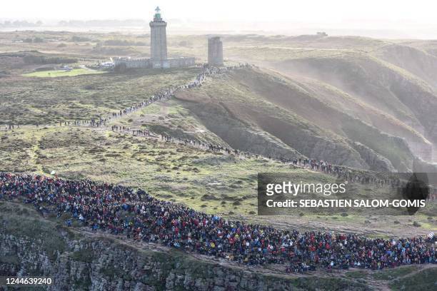 People gather at the Cap Frehel, in Plevenon, western France, to watch the start of the Route du Rhum solo sailing race on November 9, 2022. - The...