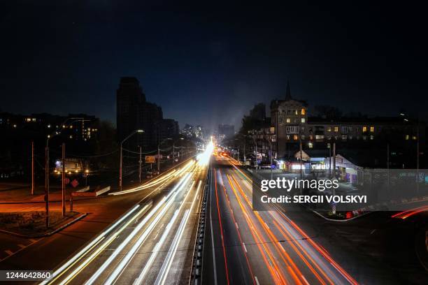 This photograph taken on November 9 shows cars driving at night during a blackout after a military strike partially damaged the electricity...