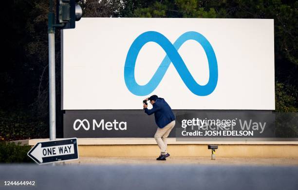 Man takes a photo at Meta corporate headquarters in Menlo Park, California on November 9, 2022. - Facebook owner Meta will lay off more than 11,000...