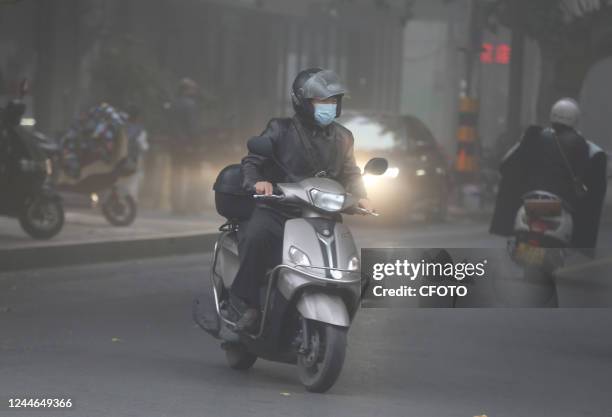 People wear masks as they travel in heavy fog in Huai 'an city, Jiangsu province, China, Nov 10, 2022.