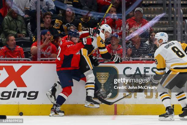 Matt Irwin of the Washington Capitals finishes a check on Jan Rutta of the Pittsburgh Penguins during a game at Capital One Arena on November 9, 2022...