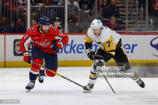 Matt Irwin of the Washington Capitals and Evgeni Malkin of the Pittsburgh Penguins race for a loose puck during a game at Capital One Arena on...