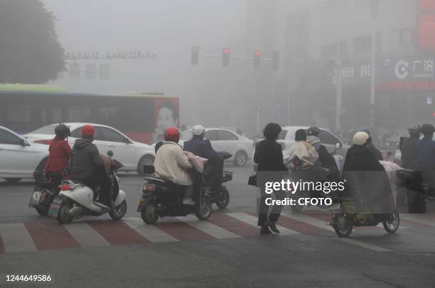 People wear masks as they travel in heavy fog in Huai 'an city, Jiangsu province, China, Nov 10, 2022.