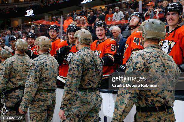 Anaheim Ducks and Military service members high five on Military Appreciation Night prior to the game against the Minnesota Wild at Honda Center on...