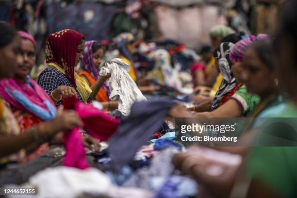 Workers sift through piles of clothes at the sorting area of the factory floor at Canam International Pvt., in Kandla, India, on Friday, Sept. 9,...