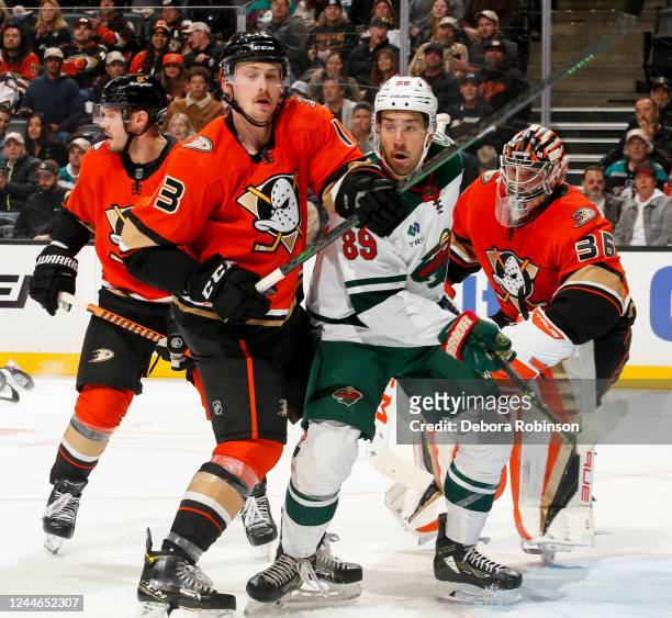 Simon Benoit of the Anaheim Ducks, Frederick Gaudreau of the Minnesota Wild and John Gibson of the Anaheim Ducks battle for position during the...