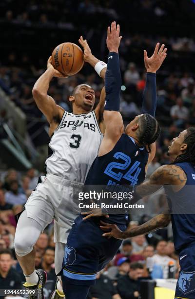 Keldon Johnson of the San Antonio Spurs shots over Dillon Brooks of the Memphis Grizzlies chases down a loose ball against the San Antonio Spurs in...