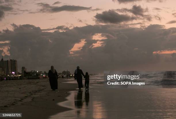 Palestinian refugees walk on the beach west of Gaza City.