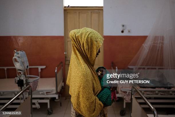 Mother cradles her child suffering from severe malnutrition in the ICU of Bay Regional Hospital in Baidoa, Somalia on November 9, 2022. - After four...