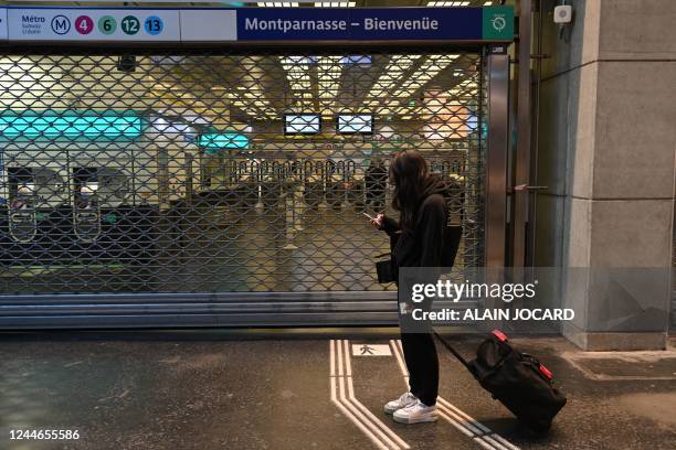 Passenger waits in front of a closed gate of the Gare Montparnasse subway station during a strike in Paris on November 10, 2022. - Seven lines of the...