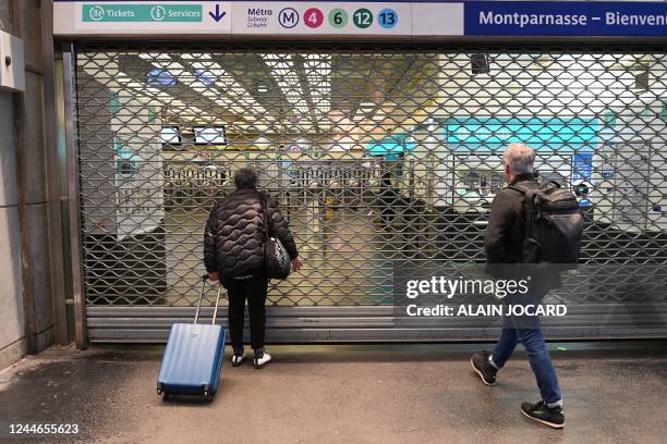 Passengers wait in front of a closed gate of the Gare Montparnasse subway station during a strike in Paris on November 10, 2022. - Seven lines of the...