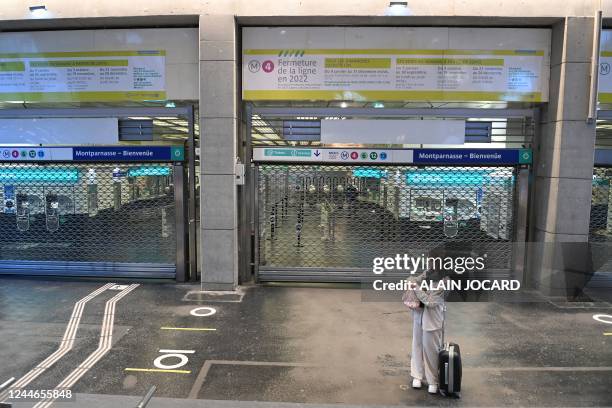 Passenger waits in front of a closed gate of the Gare Montparnasse subway station during a strike in Paris on November 10, 2022. - Seven lines of the...