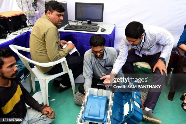 Polling officials check EVMs and other materials before dispatching them to the respective destinations ahead of Indias Gujarat states assembly...