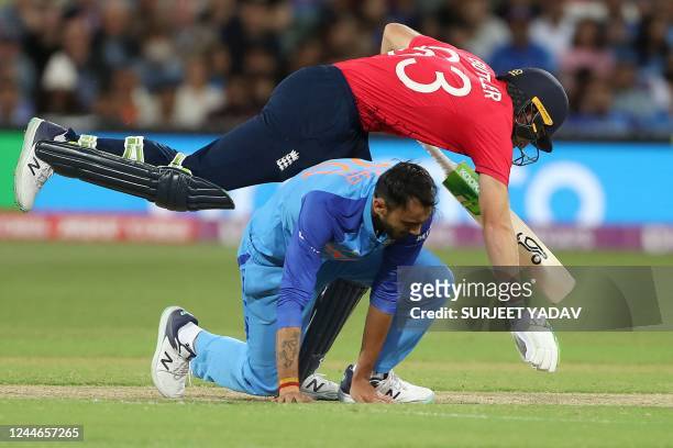 England's Captain Jos Buttler jumps over the India's Axar Patel as he runs between the wickets during the ICC men's Twenty20 World Cup 2022...