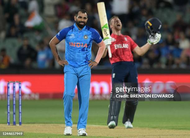 England's Captain Jos Buttler celebrates after victory as India's Mohammed Shami looks on in the ICC men's Twenty20 World Cup 2022 semi-final cricket...