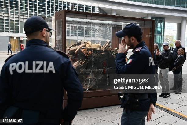 Police officers stand by as the remains of the armoured Fiat Croma which code name was 'Quarto Savona Quindici', the escort car of late Italian judge...