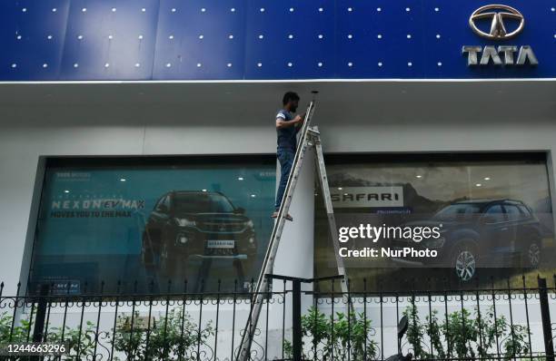 Worker is seen in front of a Tata Motors showroom in Mumbai, India, 10 November, 2022. Tata Motors shares fall over 4% post Q2 earnings according to...