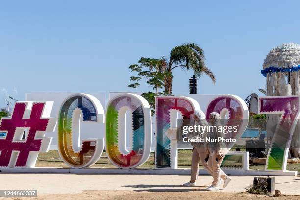 Participants walk in front of COP27 logo in the Green Zone on the fourth day of the COP27 UN Climate Change Conference, held by UNFCCC in Sharm...